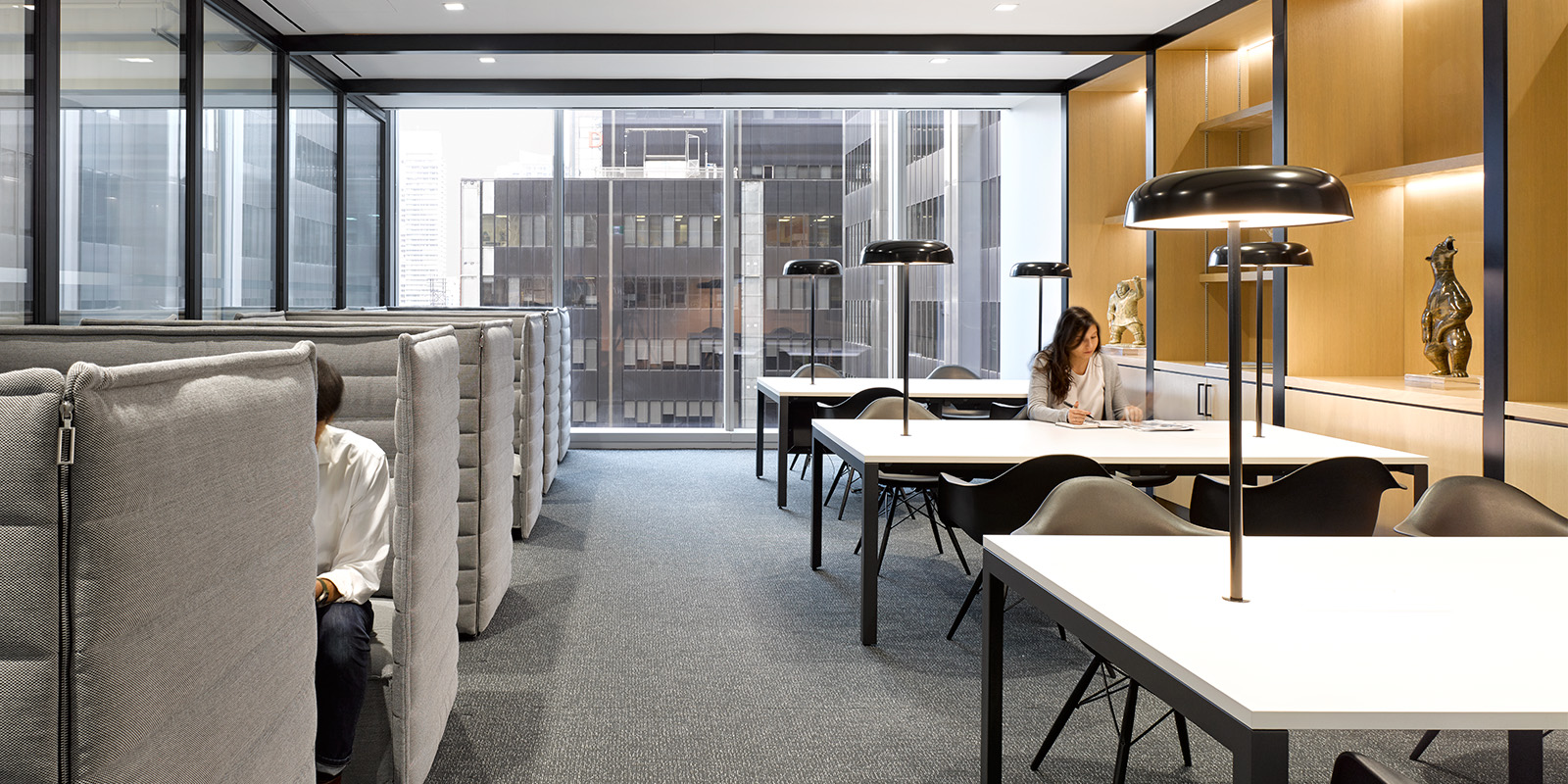 OMERS office library with tables, lamps, and upholstered booth seating