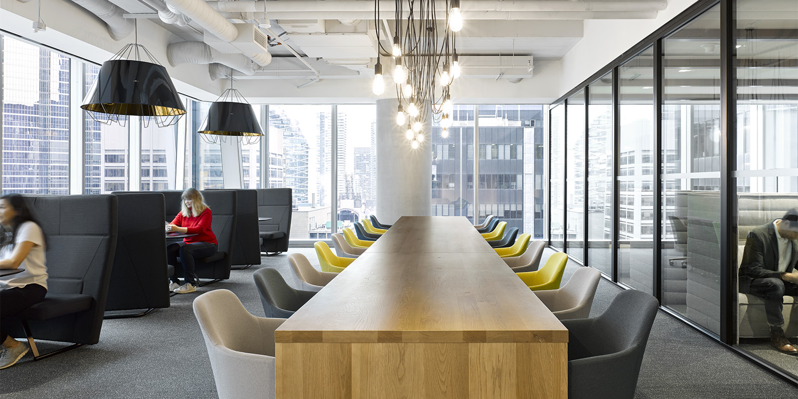 OMERS office shared space with conference table, upholstered chairs, and industrial lighting
