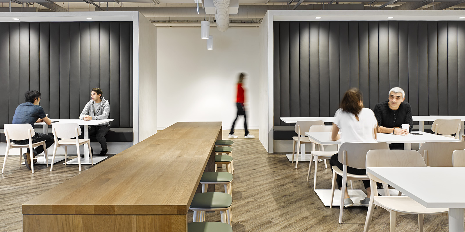 OMERS office lunchroom with long wood table, white tables and chairs, and booths