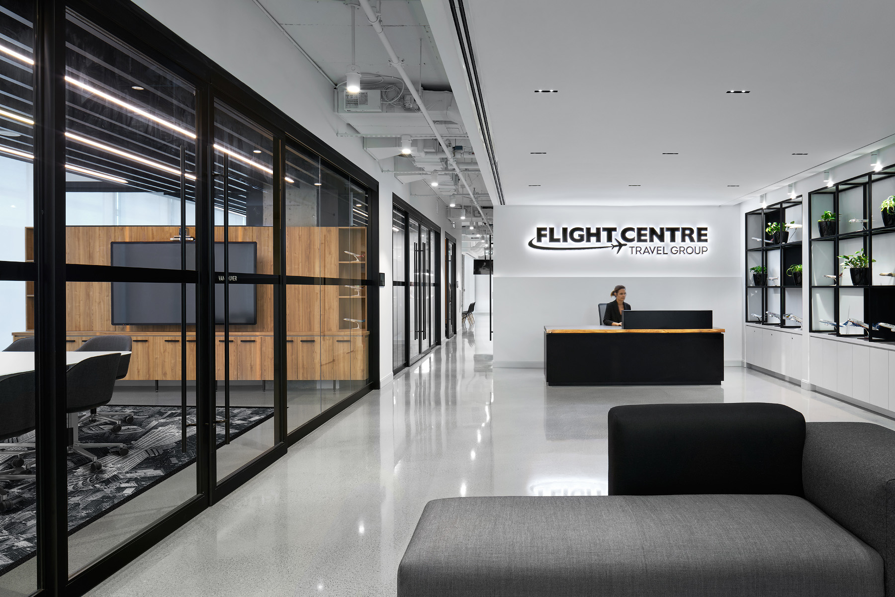 Flight Centre Vancouver reception area with Flight Centre logo, next to meeting room with glass walls